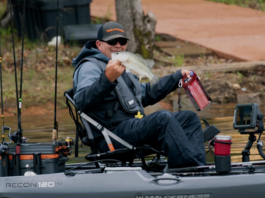 kayak angler holding up a bass