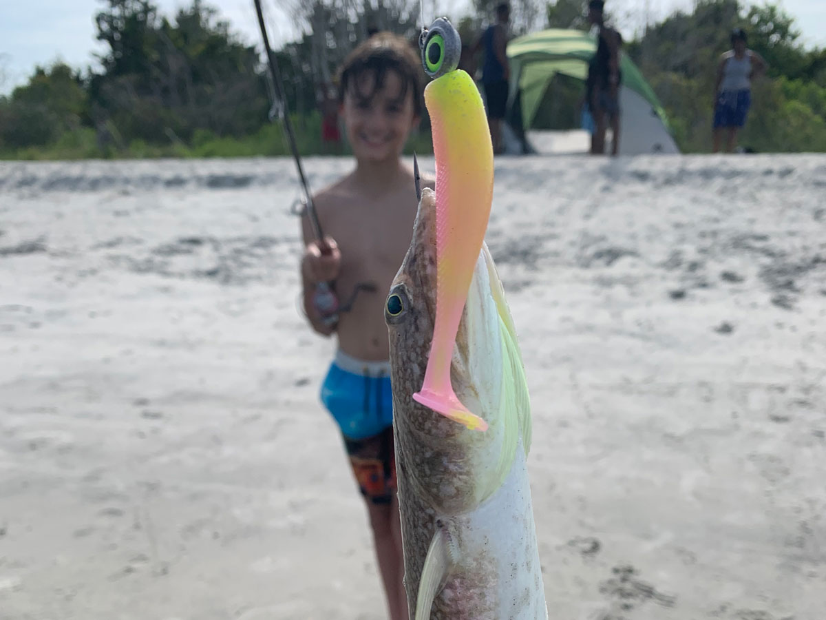 boy holding up lizard fish